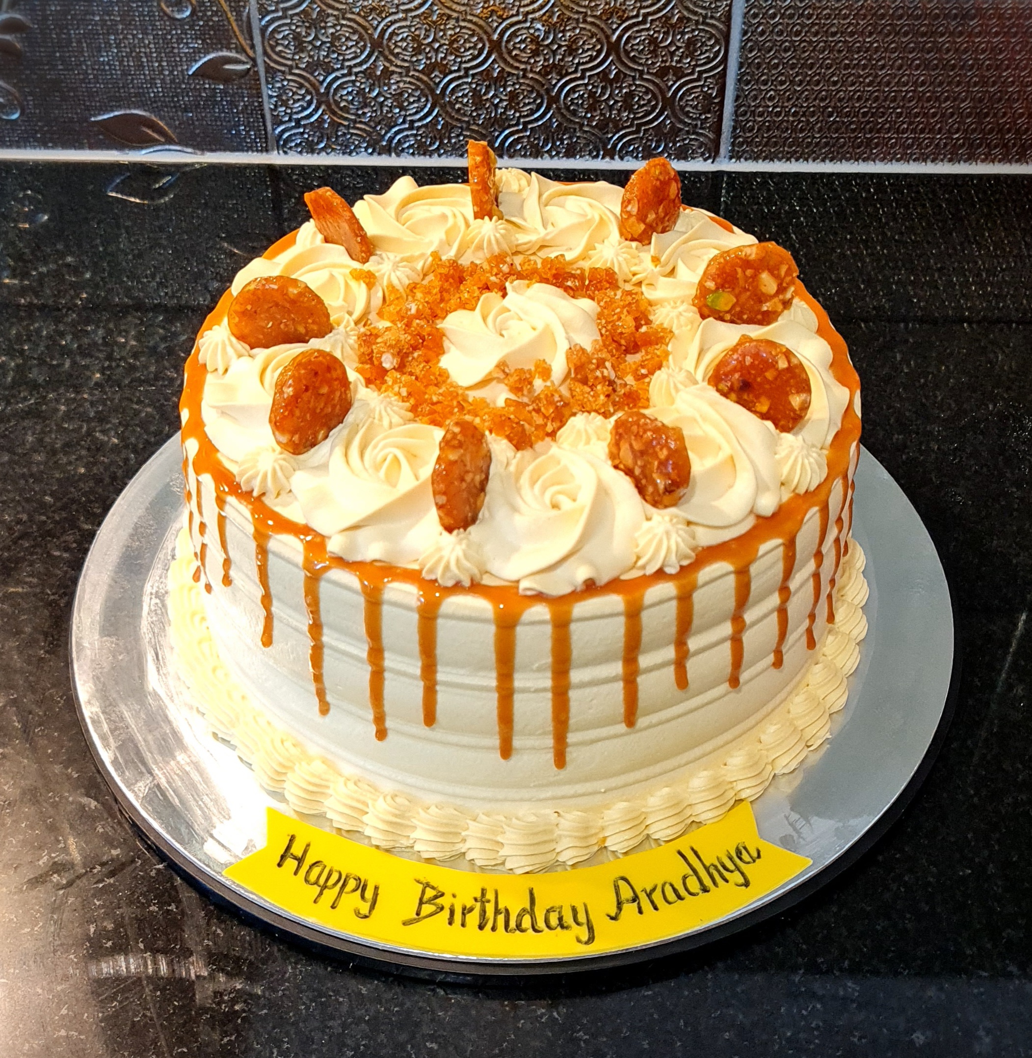 Butterscotch Fresh Cream Cake with caramel drip and decorative elements for Aradhya's birthday celebration