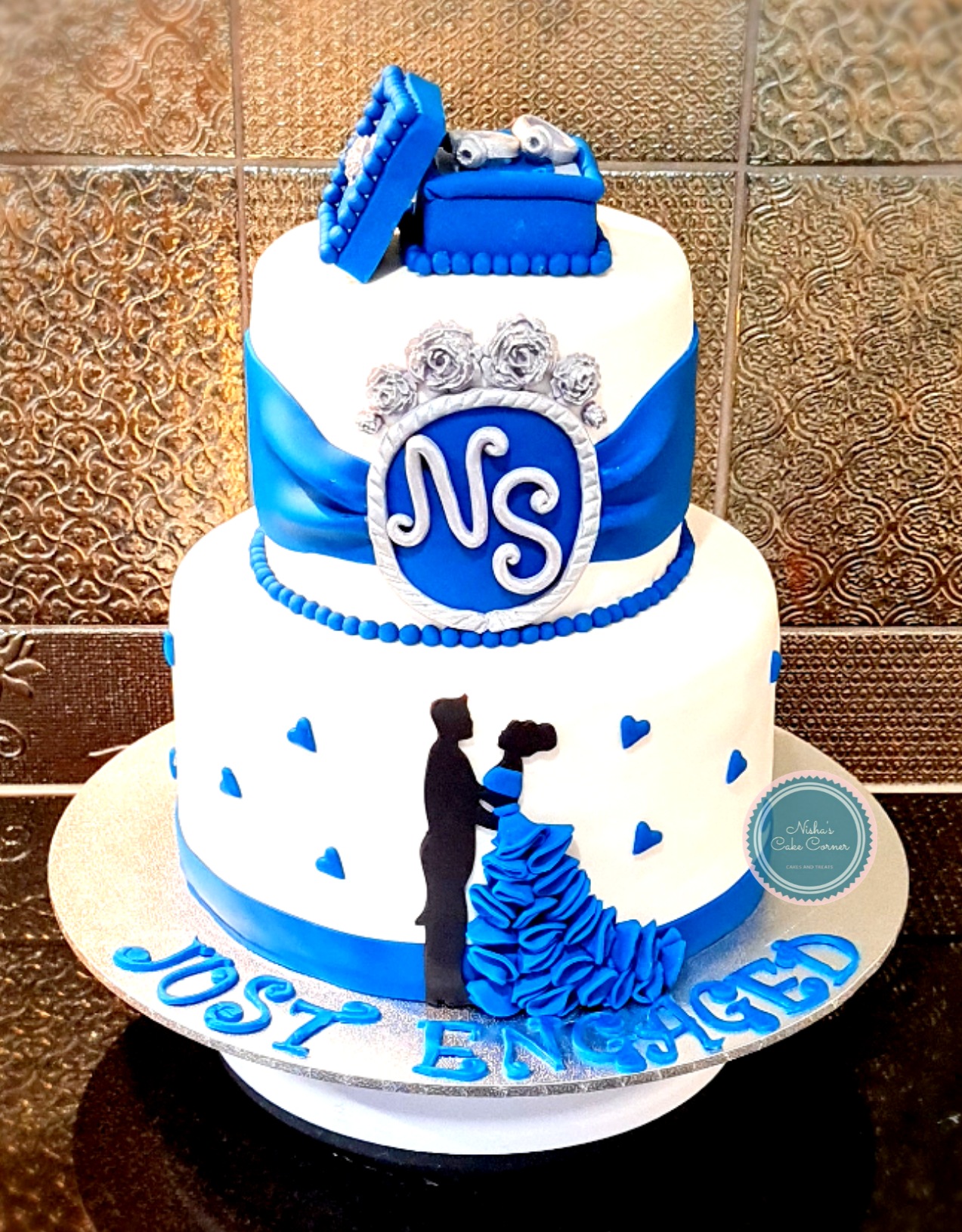 Two-tier blue and white engagement cake with NS monogram and couple silhouette, 'Just Engaged'