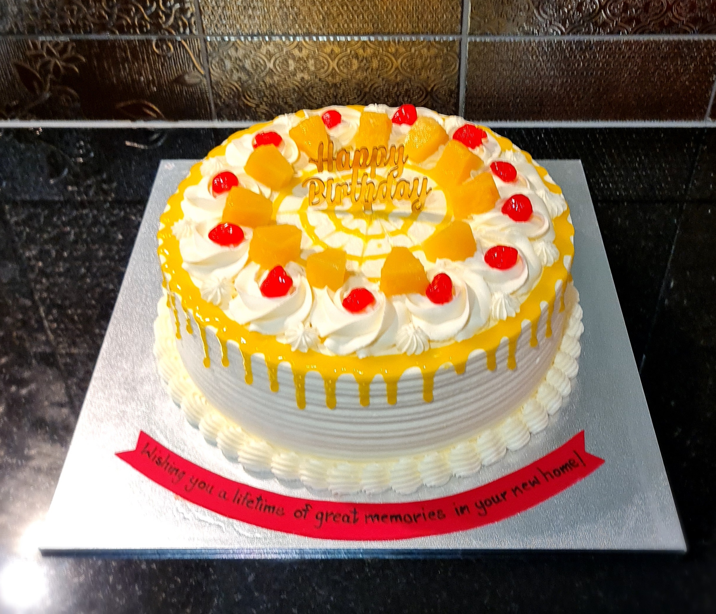Mango Fresh Cream Cake with white cream rosettes, mango pieces and red cherries for birthday celebration