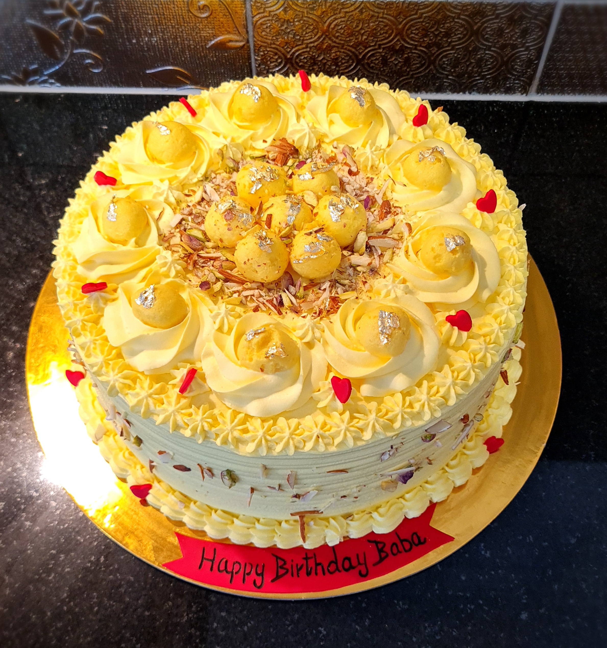 Rasmalai Fresh Cream Cake with traditional Indian sweet elements, yellow cream and nuts for Baba's birthday